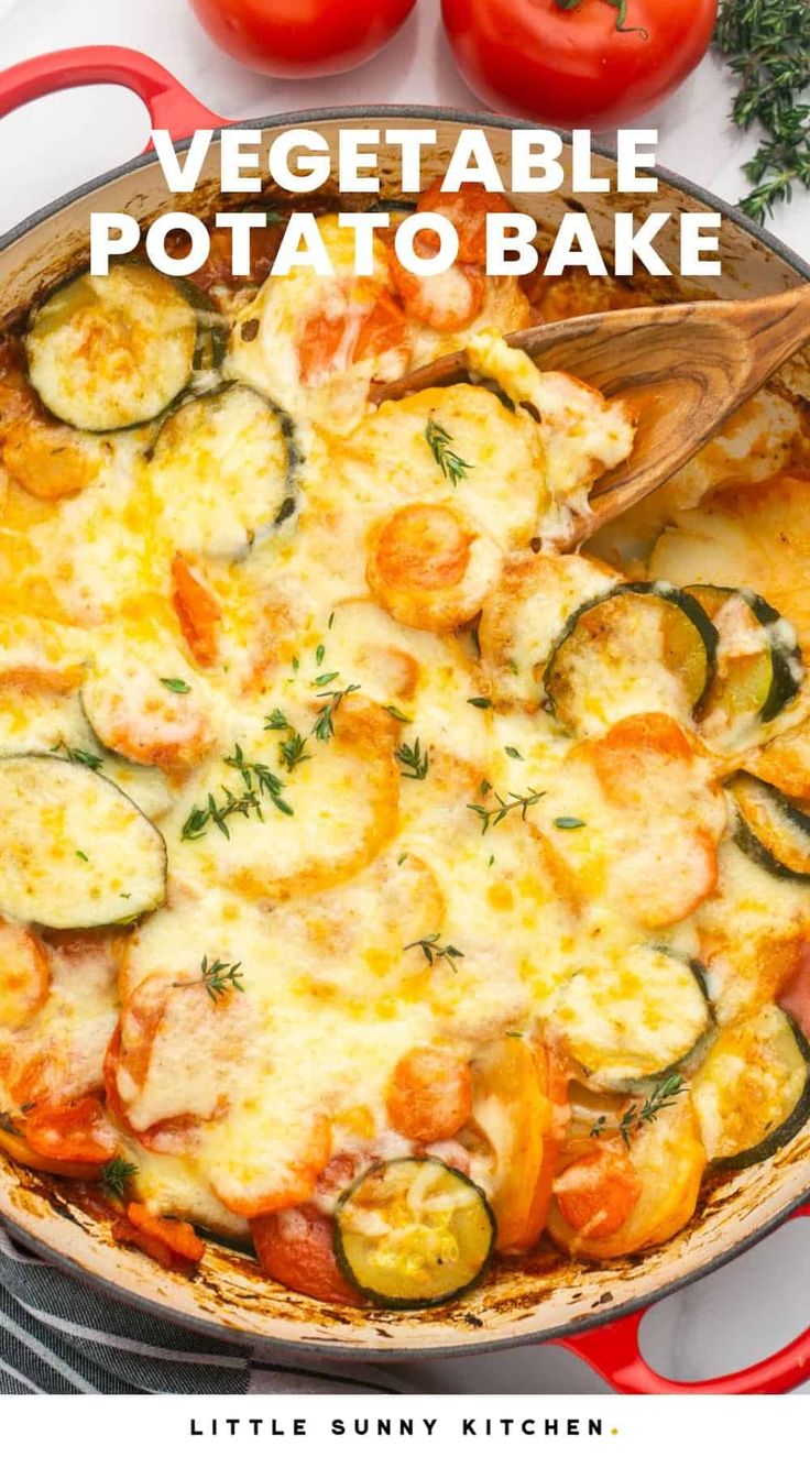 a pan filled with vegetable potato bake on top of a white table next to tomatoes