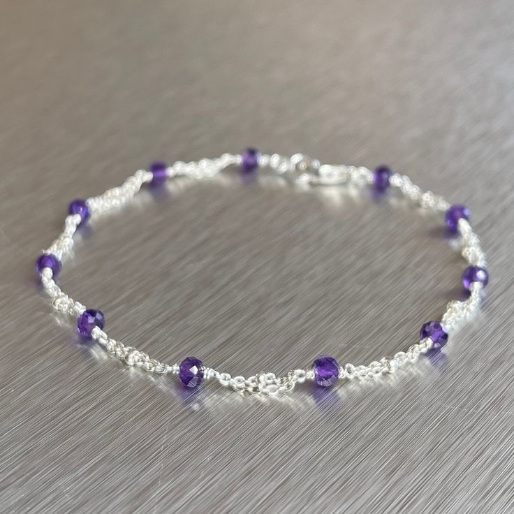 a purple and white beaded bracelet sitting on top of a table