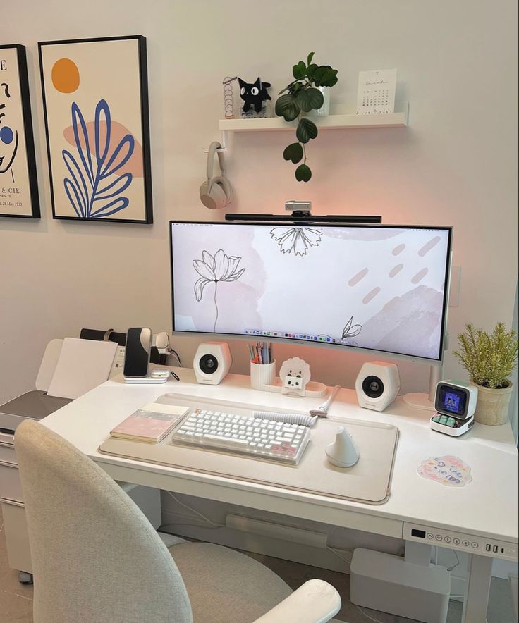 a desk with a computer monitor, keyboard and mouse on it in front of two pictures