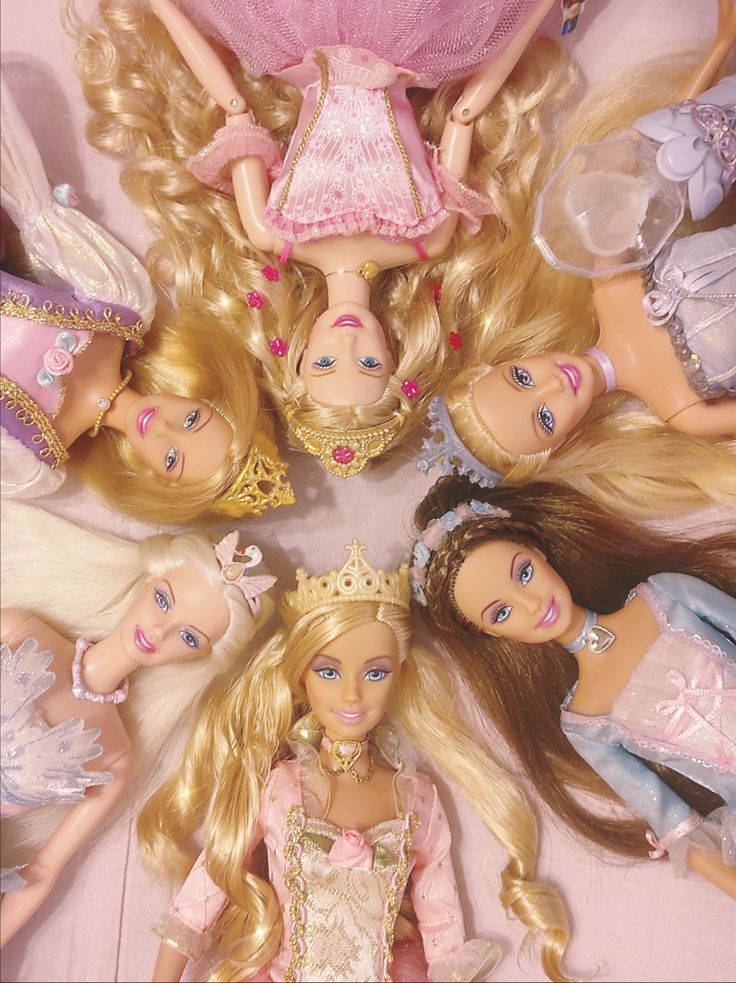 there are many barbie dolls in the middle of a circle with tiaras on their heads