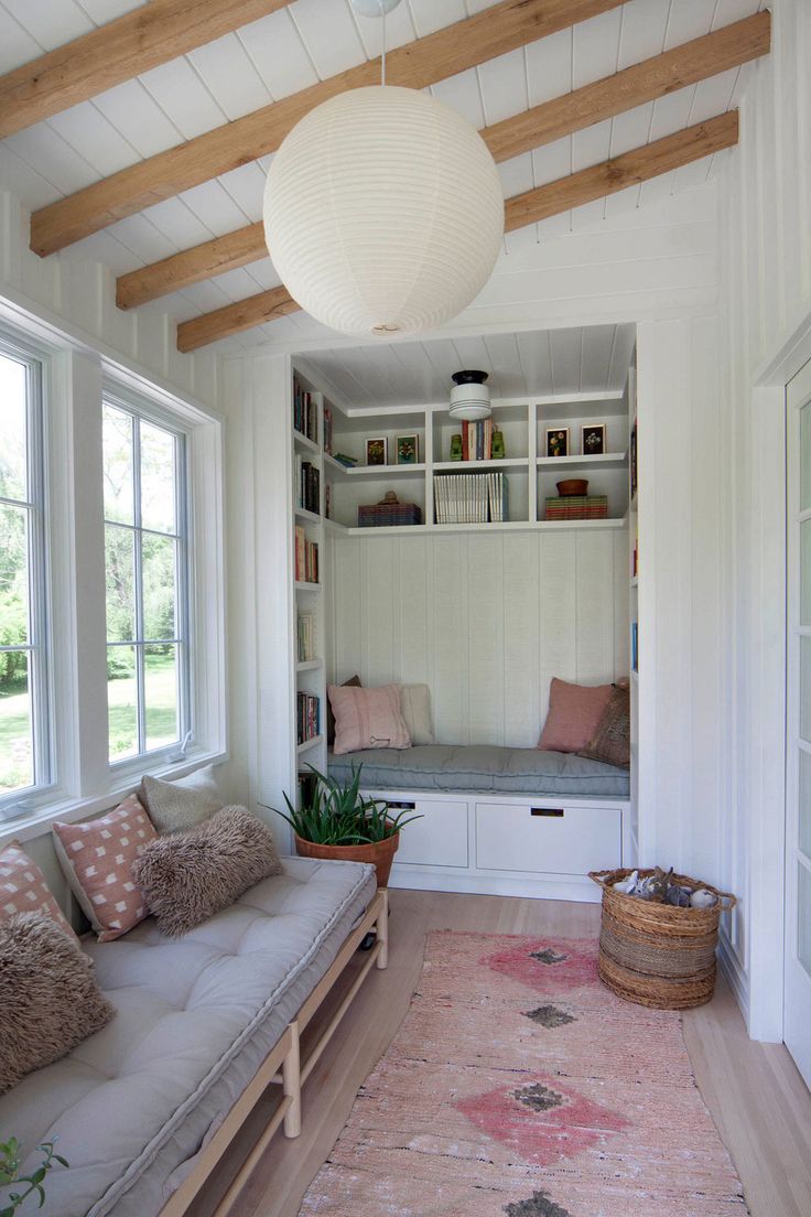 a living room with white walls and wooden beams