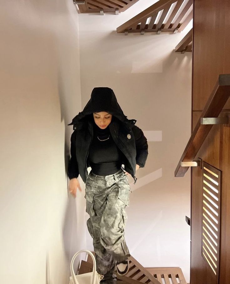 a woman in black jacket walking up stairs