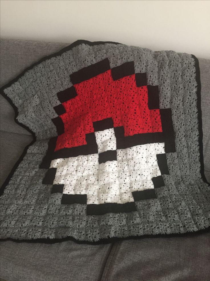 a crocheted blanket with an image of a red and white mushroom on it