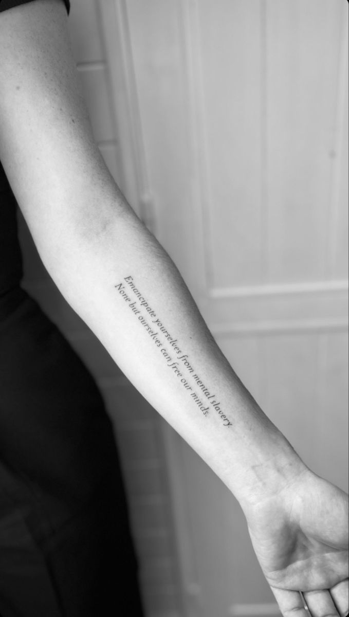 a woman's arm with a quote tattooed on it