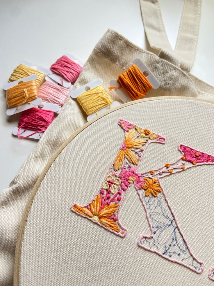 a close up of a embroidery on a piece of cloth with scissors next to it