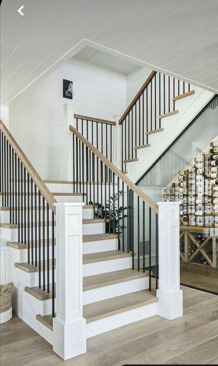 there is a stair case in the middle of this room with white walls and wood floors