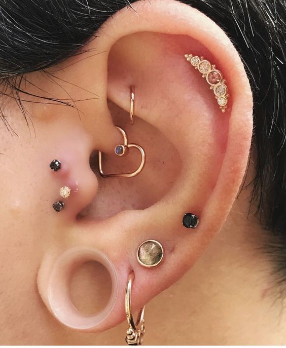 an ear with three different types of piercings attached to the side of its ear