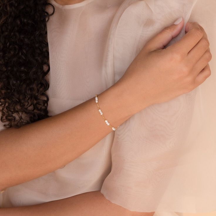 Our elegant and delicate Hali Pearl Station Bracelet is the ultimate accent to your bridal look. Give this minimalist charm bracelet as a gift to your bridesmaids or gift to yourself on the big day. Material: High Quality Solid 925 Sterling Silver Finish: Sterling Silver ∙ 18K Gold Featuring ~3-5mm Pearl Charms on a minimalist chain, adjustable 6 to 8 inches Part of the Casablanca Collection SKU: RR-BR038 Dainty White Bracelets For Bridesmaid Gift, Adjustable Elegant Name Bracelet, Delicate White Bracelets For Bridesmaids, Dainty Wedding Jubilee Charm Bracelet, Delicate White Bracelet For Bridesmaid, Minimalist White Jubilee Chain Bracelet, Elegant Adjustable Charm Bracelet For Wedding, Elegant Charm Bracelet For Anniversary, Elegant Wedding Charm Bracelet Adjustable