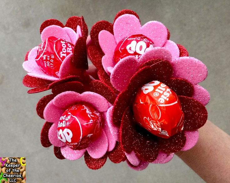 a hand holding a candy bouquet with chocolate candies in it