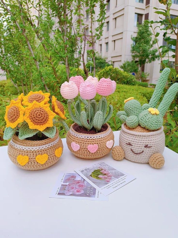 three crocheted potted plants on a table