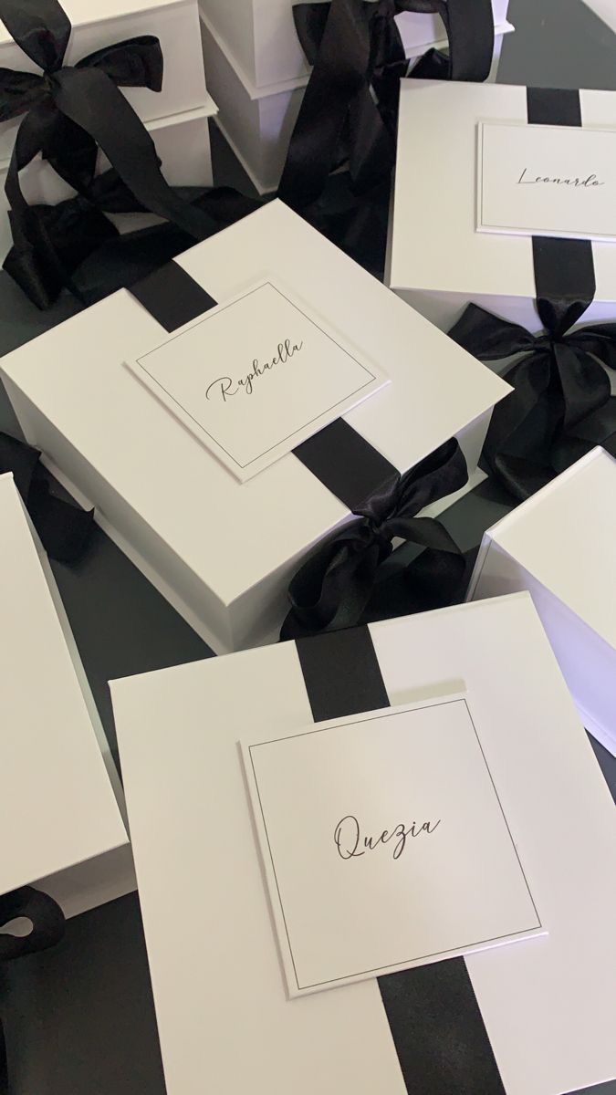 several white boxes with black ribbons and bows