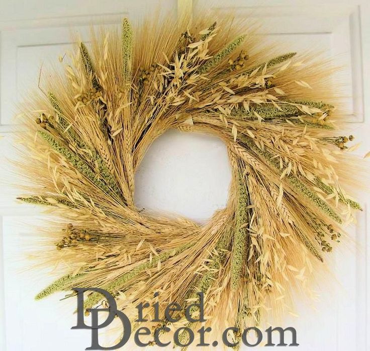 a wreath made out of dried grass hanging on a door