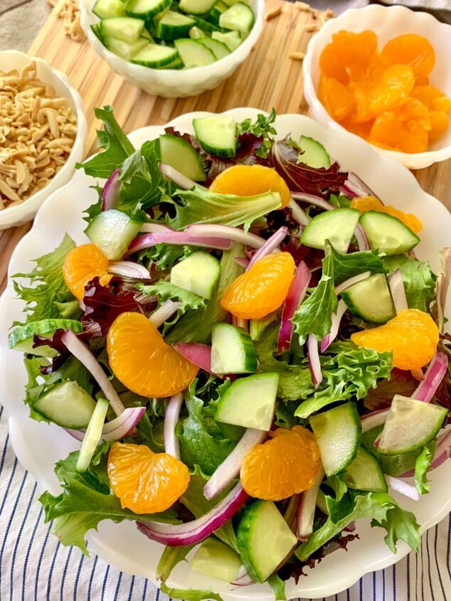 a salad with oranges, cucumbers, and other vegetables on a table