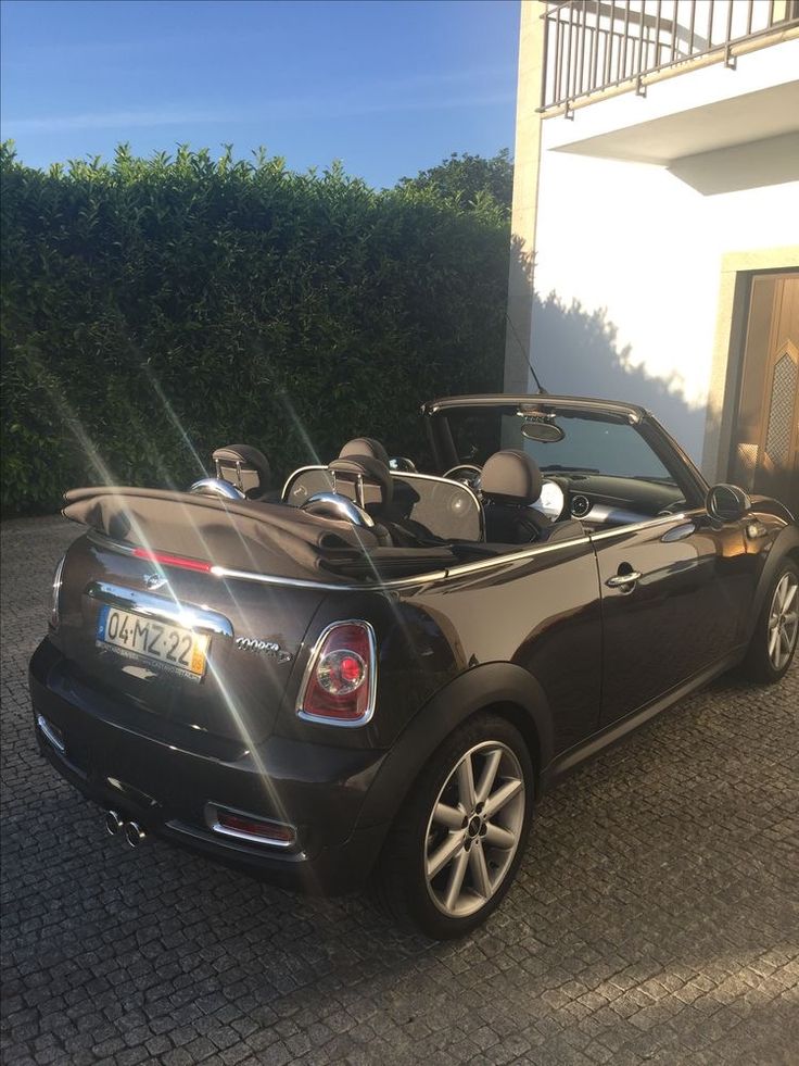 a black convertible car parked in front of a house