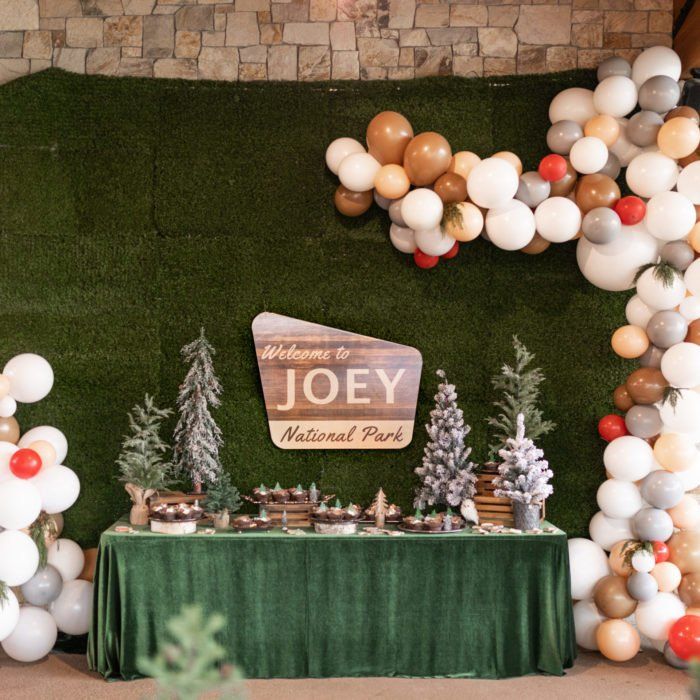 a table topped with lots of balloons next to a sign that says joey natural park