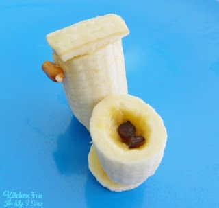 a peeled banana sitting on top of a blue plate with nuts in the middle and one piece cut out