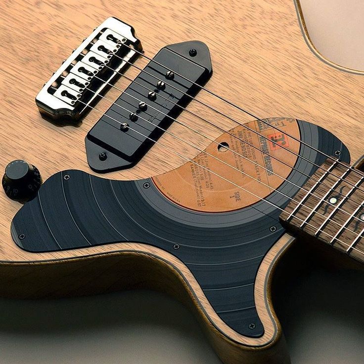 an electric guitar with a wooden body and black fret cover on it's neck