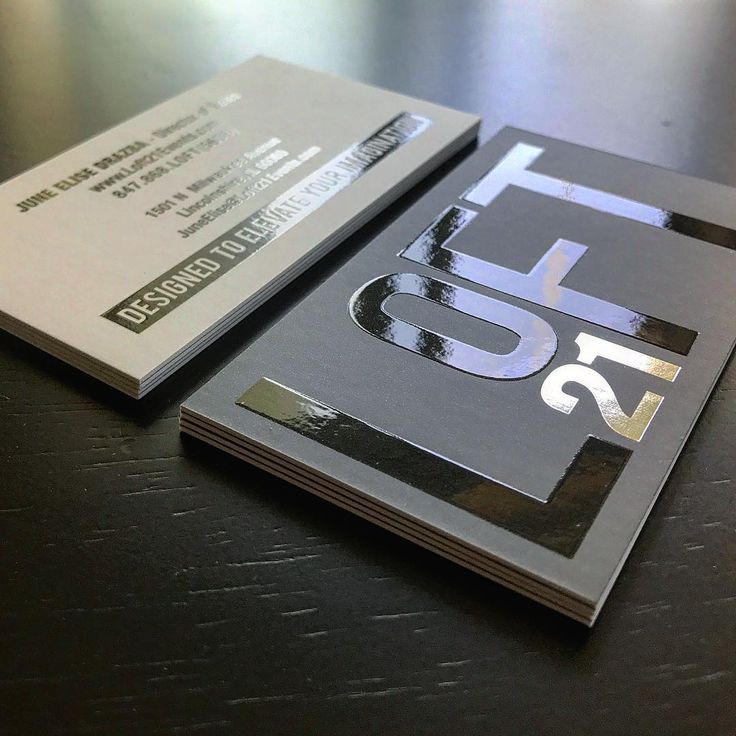 two business cards sitting on top of a wooden table with the number 55 printed on them