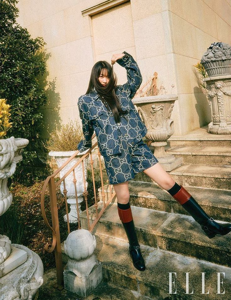 a woman standing on some steps with her legs up in the air and wearing knee high boots