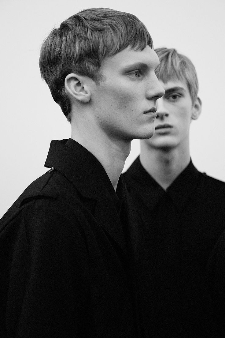 two young men standing next to each other wearing black shirts and ties on their collars