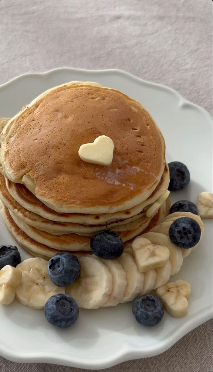 a stack of pancakes with blueberries and bananas on a plate