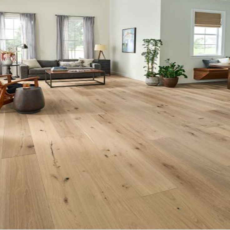 a living room filled with lots of furniture and wood flooring on top of hard wood floors