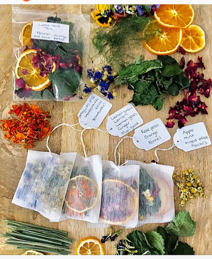 various herbs and oranges on a table with tags attached to them that say,