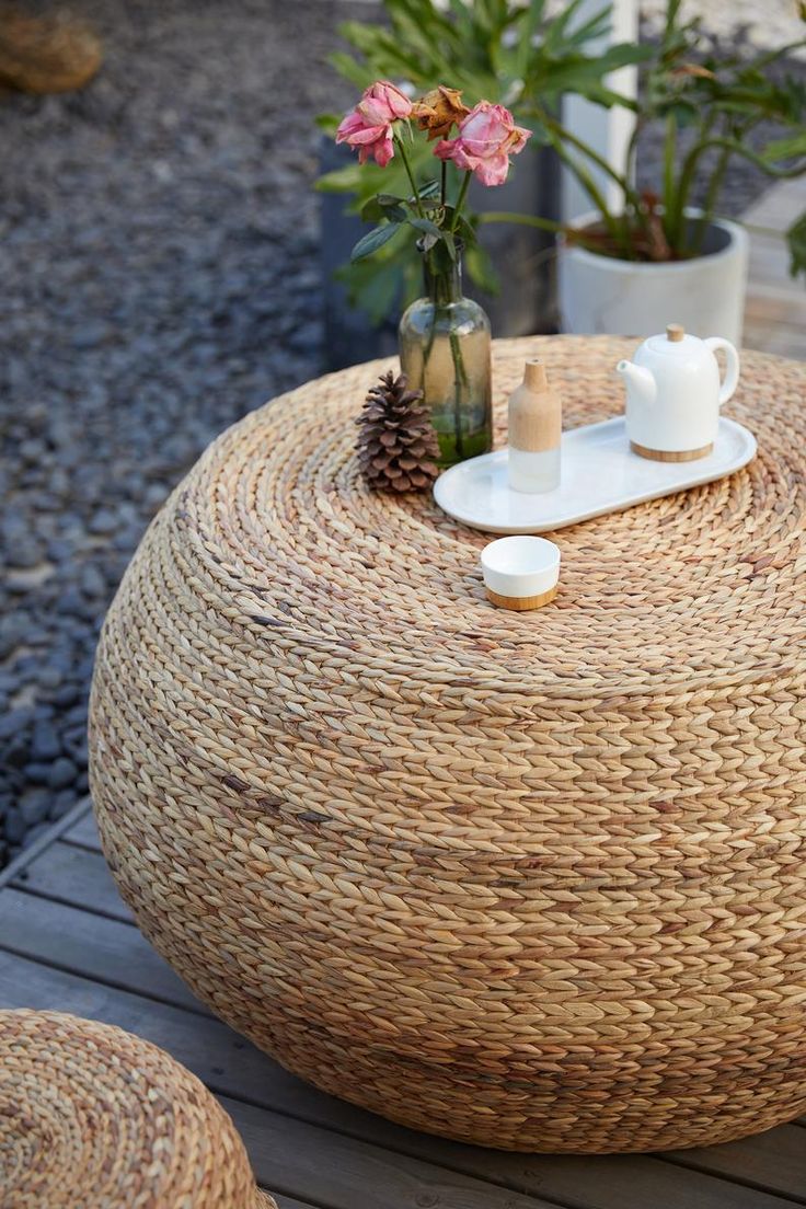 a wicker coffee table with two cups on it