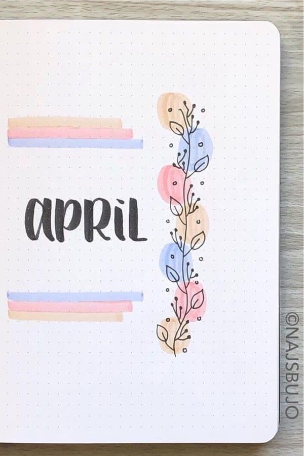 an open notebook with the word april written in black ink on it and colorful flowers