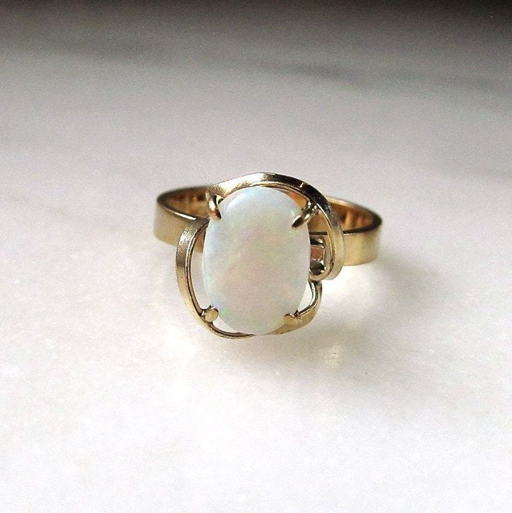 This is a vintage womens 14K yellow gold opal gemstone ring.  The band is sized at a 7.  The genuine opal gemstone measures 10mm long x 7mm wide.  Total weight of the ring is 3.0 grams.  The inside of the band is not marked, but we did test the karat quality of the gold.  It is 14K. This is a vintage, previously owned ring.  Therefore, light wear can be expected.  There is no visible damage. Butterfly Ring, White Band, Great Memories, Opal Gemstone, Gemstone Ring, Rings Statement, Statement Rings, Vintage Ladies, Gemstone Rings