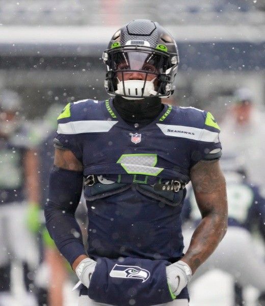 a football player standing on the field in the rain