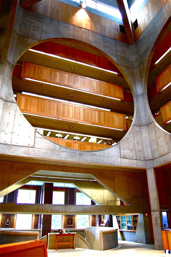 the inside of a large building with two circular windows and wooden paneled ceilinging