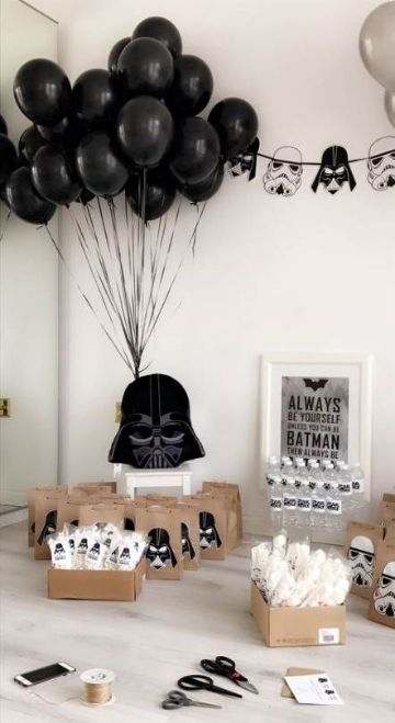 star wars party supplies and balloons on a table with darth vader mask decorations