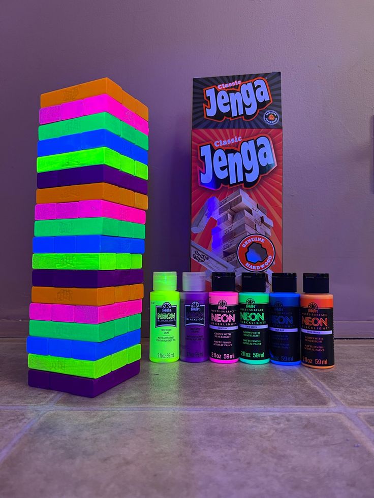 a stack of neon colored building blocks next to an unopened box of paint