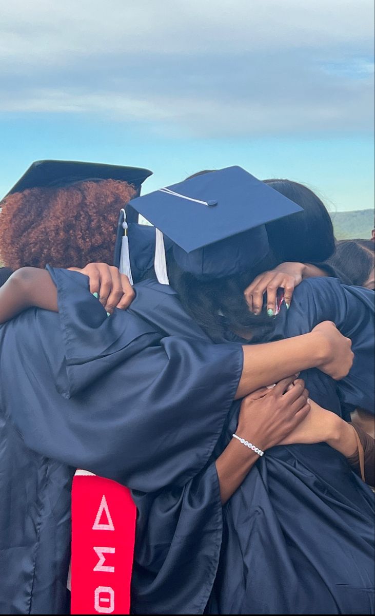 two graduates hugging each other at graduation