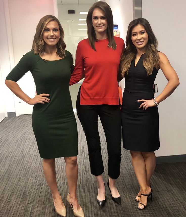 three women standing next to each other in an office