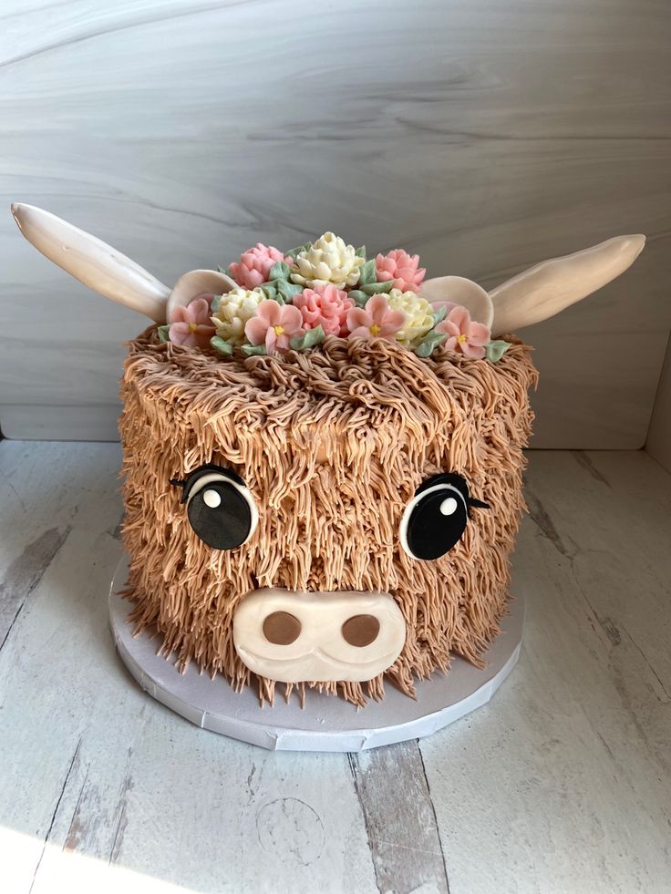 a cake decorated to look like a cow with flowers on it's head and ears