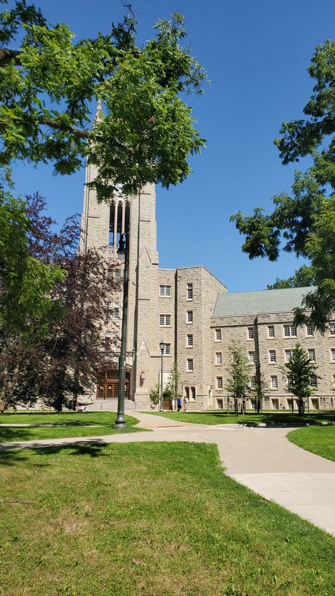 a tall building with a clock tower in the middle of it's front yard