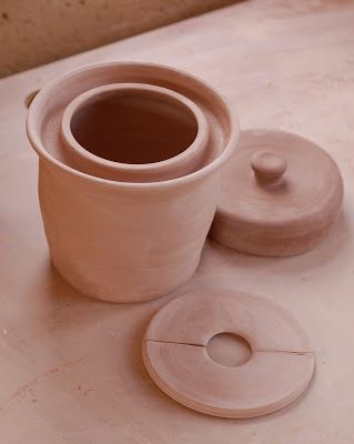 a clay cup and saucer sitting on a table