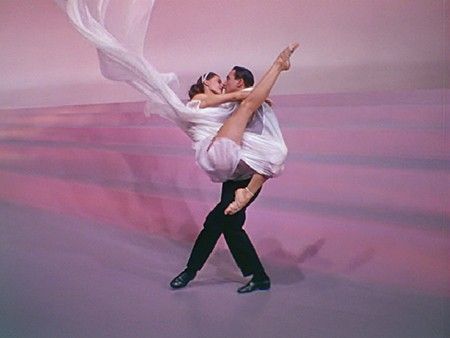 a man and woman are dancing together in the middle of an artistic dance pose with white fabric