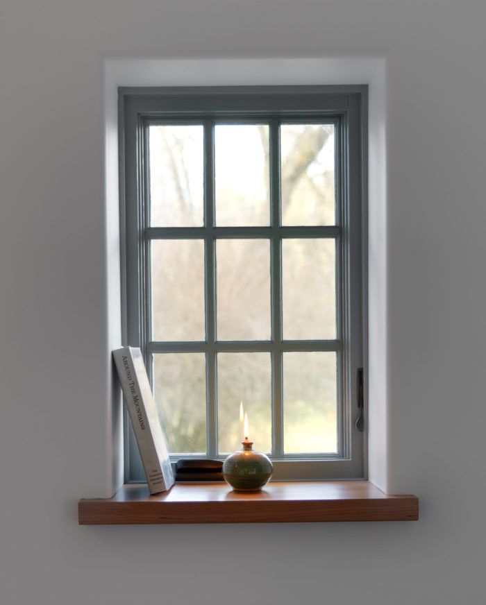 a window sill with a book and candle on it