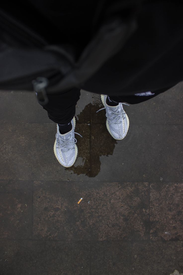 a person standing in the rain with their shoes on