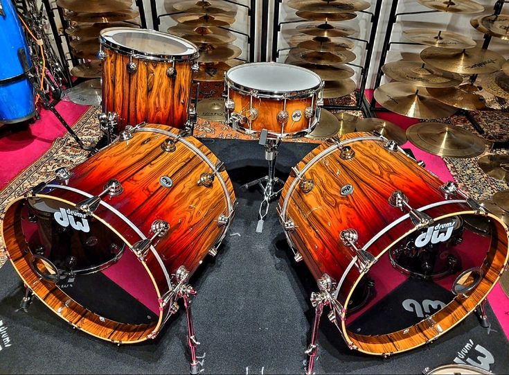 a group of drums sitting on top of a floor next to other musical instruments in a room