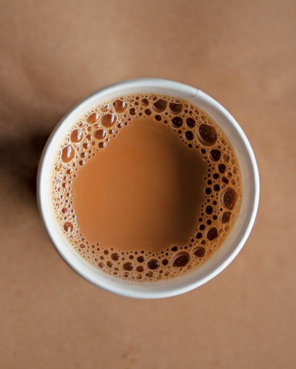 a cup of coffee on top of a table with the words breakfast written in it