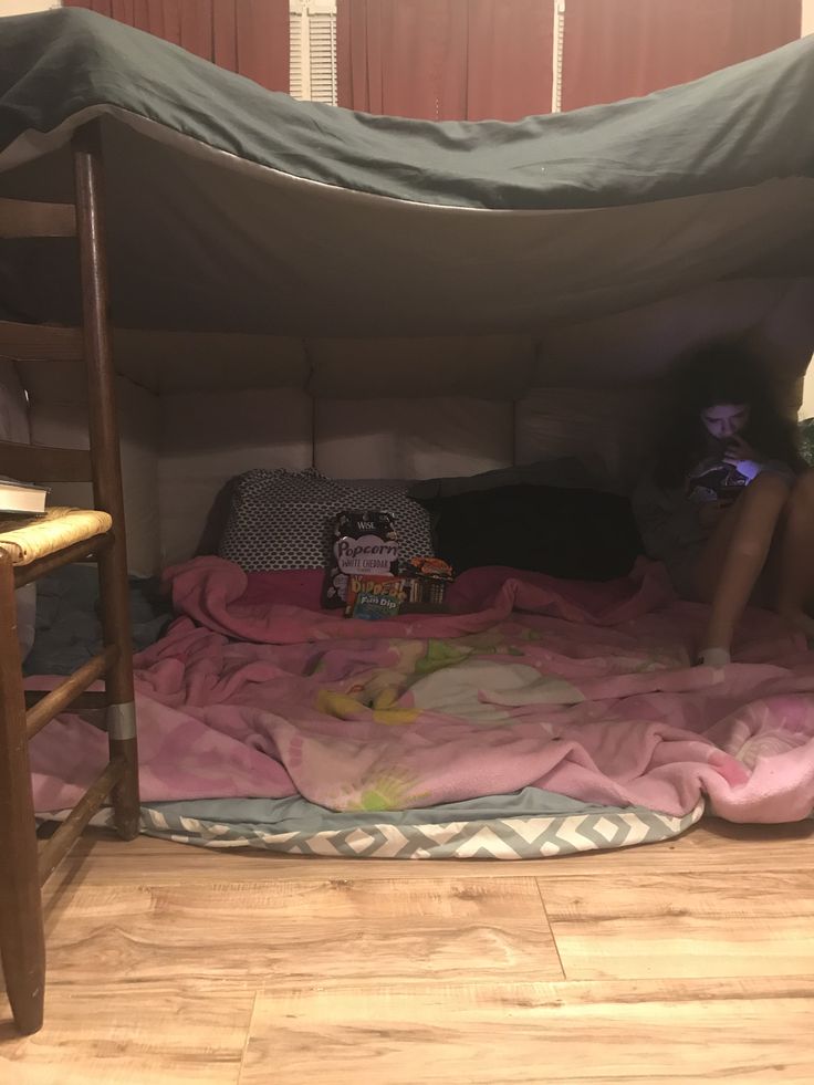 a woman sitting on top of a bed under a tent