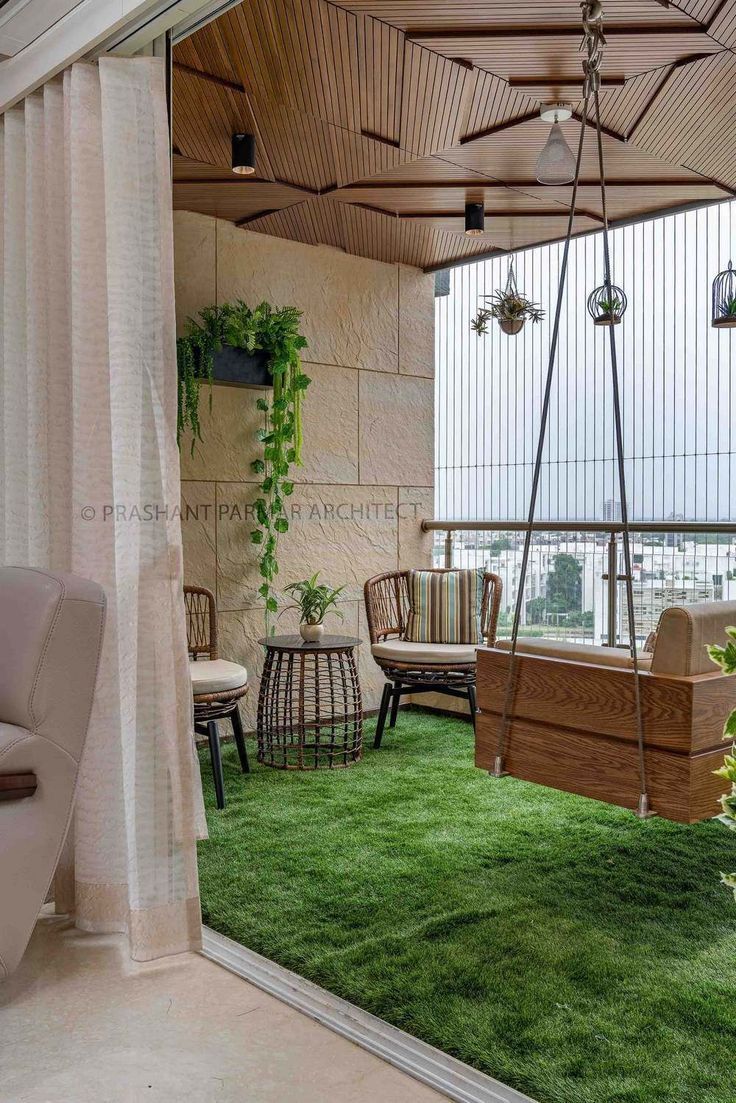 an outdoor living area with green grass and wooden furniture on the balcony overlooking the city