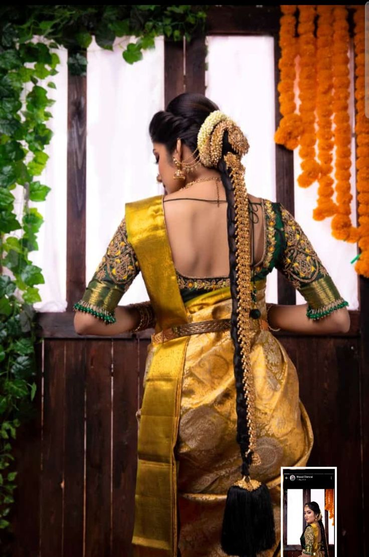 a woman in a yellow sari with braids on her head and an orange garland behind her back