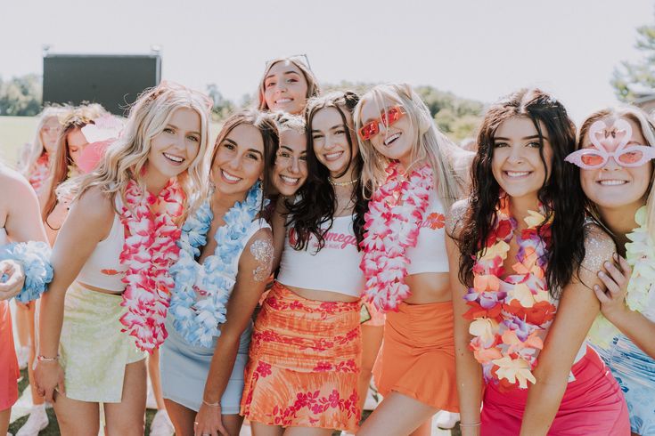 a group of young women standing next to each other in front of a crowd wearing leis