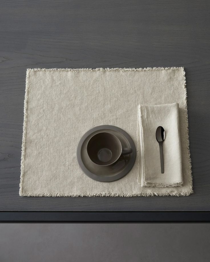 a place mat with a bowl, spoon and napkin on it