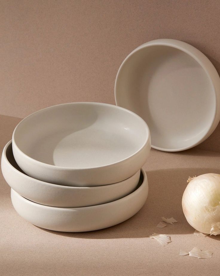 an onion is next to three white plates